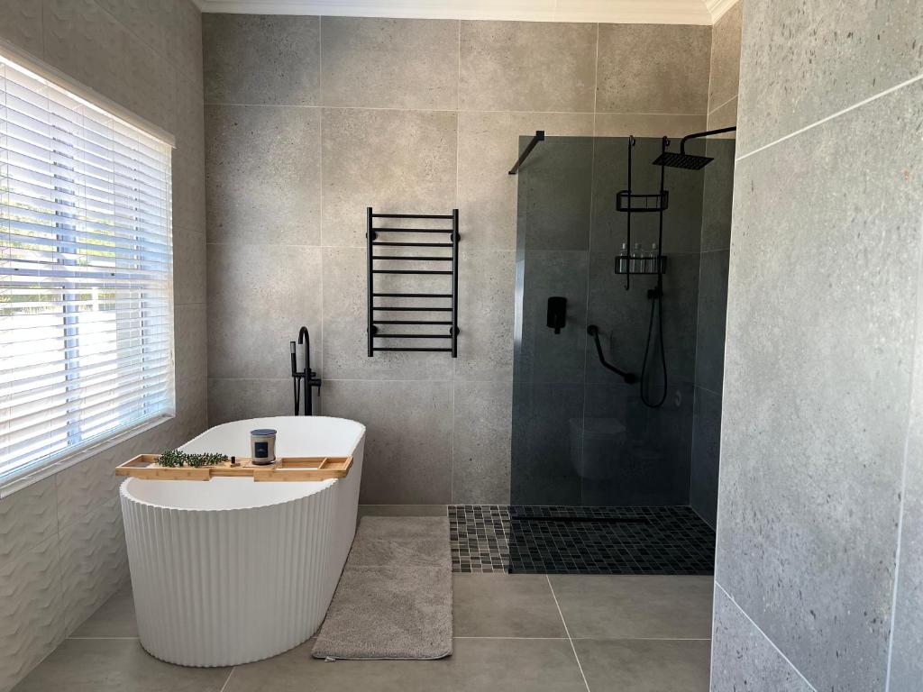 Bathroom with a freestanding bath, walk-in shower and grey stone tiles